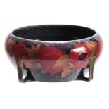 AN EARLY 20TH CENTURY MOORCROFT BOWL DECORATED WITH POMEGRANATES having stylised feet - signed
