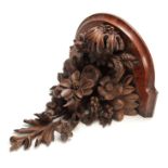 A LATE 19th CENTURY WALNUT AND OAK CARVED BRACKET having a floral spray and fruit 30cm high