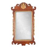 A GEORGE II WALNUT HANGING MIRROR with shaped fret cut surround having gilt carved crest and leaf