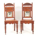 A PAIR OF EARLY 20TH CENTURY ARTS AND CRAFT OAK HALL CHAIRS of aesthetic design having ceramic