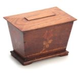 AN ARTS AND CRAFT INLAID OAK TEA CADDY of tapered form with moulded hinged top above a floral inlaid