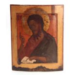 AN EARLY RUSSIAN POLYCHROME PAINTED ICON OF A SAINT on a bowed fruitwood panel 52.5cms high by 41cms