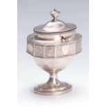 A LATE GEORGIAN SILVER PLATE OVAL PEDESTAL TEA CADDY the facetted body with gadrooned edges and