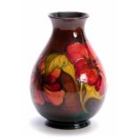 A WALTER MOORCROFT FLAMBE BALUSTER VASE with colourful tube lined Hibiscus flower head and leaf