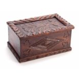 A LATE 17TH CENTURY CARVED OAK CANDLE BOX with sliding top having a gadrooned edge and flower carved