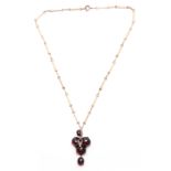 A YELLOW GOLD SET DARK RED STONE PENDANT WITH CLIP ATTACHMENT AND FINE LINK CHAIN the three stone
