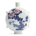 AN 18TH / 19TH CENTURY CHINESE MOON FLASK decorated with iron red and blue floral work decoration,