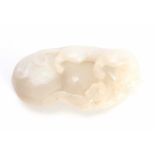 A CHINESE CARVED WHITE JADE SCULPTURE depicting a Leopard climbing a rock 6cm overall 3cm wide.