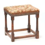 A RARE LATE 17TH CENTURY OAK UPHOLSTERED JOINT STOOL with tapestry top; standing on ring turned