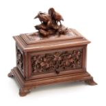 A LATE 19TH CENTURY SWISS WALNUT CIGAR CABINET with carved fruiting leaf work panels to the front