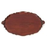 A 19TH CENTURY MAHOGANY OVAL SHAPED MAHOGANY TRAY with a pie crust edge, having carved shell handles