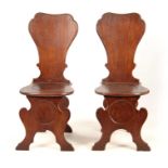 A PAIR OF GEORGE II OAK HALL CHAIRS the slightly bowed shaped solid backs on dished rounded seats