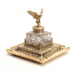 AN IMPRESSIVE LATE 19TH CENTURY BRASS INKWELL OF LARGE SIZE having a square-shaped moulded glass