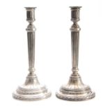 A PAIR OF GERMAN SILVER CANDLESTICKS having reeded columns and fluted circular bases with acanthus