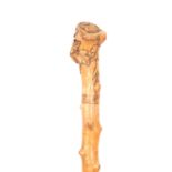 A LATE 19TH CENTURY TAPERING KNOTCHED WALKING STICK with leaf and berry carved knop handle 90cm