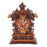A LATE 19th CENTURY BLACK FOREST CUCKOO CLOCK the architectural pediment with carved leaf decoration