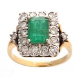 AN 18CT YELLOW GOLD EMERALD AND DIAMOND CLUSTRE RING with raised centre stone and rectangular border