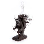 A LATE 19TH CENTURY SWISS CARVED BLACK FOREST BEAR DECANTER SET modelled as a bear carrying a