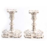 A PAIR OF 20TH CENTURY GEORGE II STYLE ROCOCO SILVER CANDLESTICKS with shell corners and ringed