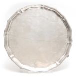 A LARGE LATE 19th CENTURY SILVER SALVER with pie crust edge supported on four cabriolet feet 45cm