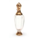 AN 18CT GOLD MOUNTED PERFUME BOTTLE with tapering faceted clear body, florally embossed foot and