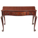 A LATE 19TH CENTURY SERPENTINE IRISH STYLE MAHOGANY SERVING TABLE with carved moulded edge above