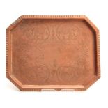 AN ARTS AND CRAFTS COPPER TRAY with moulded edge and clipped corners, having foliage engraved centre