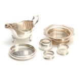 A SELECTION OF SOLID SILVER ITEMS including two wine coasters, sauceboat, three napkin rings and a