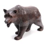 A LATE 19TH CENTURY SWISS BLACK FOREST CARVED BEAR with glass eyes 46cm wide.