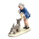 A GOLDSCHEIDER AUSTRIAN FIGURE GROUP depicting a standing boy wearing a blue coat with a dog 23cm