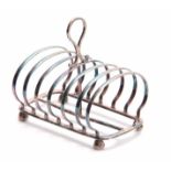 A VICTORIAN SILVER TOAST RACK of six divisional hooped form with raised ring handle and facetted