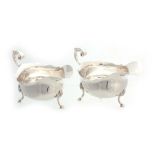 A PAIR OF 20TH CENTURY GEORGIAN STYLE SILVER SAUCE BOATS with shaped bodies and shell splayed feet -
