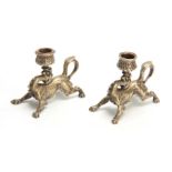 A PAIR OF 19TH CENTURY CONTINENTAL NICKEL PLATED STYLISED GRIFFIN CANDLESTICKS with raised flower