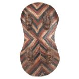 AN AFRICAN PAINTED WOODEN TRIBAL CEREMONIAL SHIELD with four carved heads 76cm high