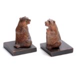 A PAIR OF LATE 19TH CENTURY SWISS CARVED BEAR BOOKENDS depicting two seated bears with glass eyes,