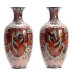 A PAIR OF 20TH CENTURY CHINESE CLOISONNE VASES decorated with animals and floral work 25cm high.