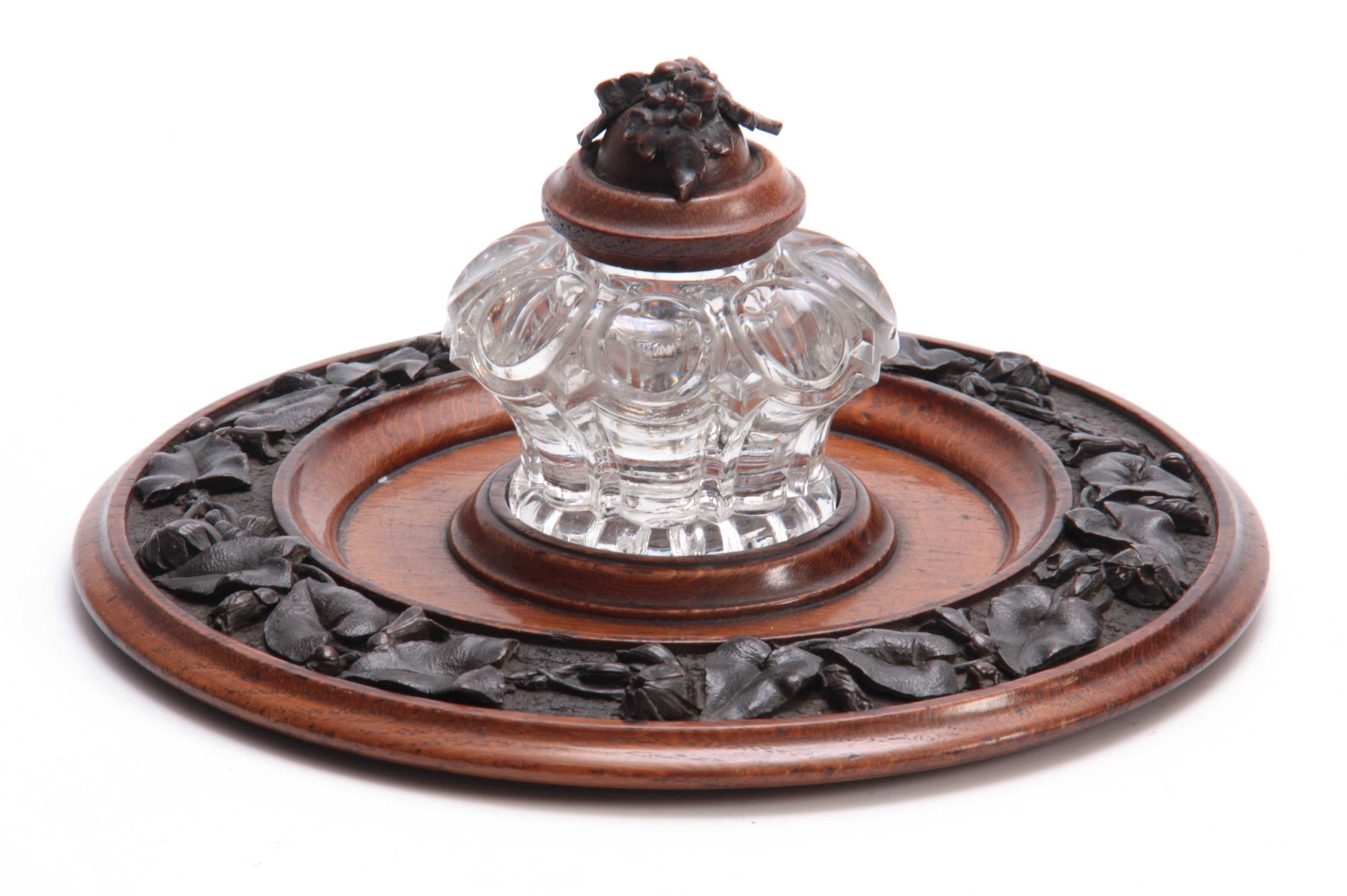 A 19TH CENTURY CARVED OAK CIRCULAR INK STAND with cut glass inkwell to the centre having a floral