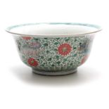 A 19TH CENTURY CHINESE FAMILLE VERTE PUNCH BOWL decorated with colourful foo dogs amongst flowers
