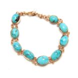 A YELLOW GOLD DOUBLE CHAIN LINK AND OVAL TURQUOISE SET BRACELET