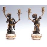A PAIR OF 19TH CENTURY BRONZE AND GILT BRONZE TWO LIGHT CHERUB CANDELABRA on white circular marble