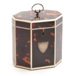 A GEORGE III TORTOISESHELL OCTAGONAL SHAPED TEA CADDY with ivory edges and shield-shaped plaque