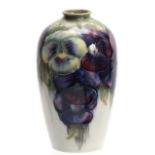 A WILLIAM MOORCROFT TAPERING SHOULDERED VASE decorated with all round leafing pansy sprays on a