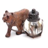 A 19TH CENTURY SWISS CARVED BLACK FOREST BEAR INKWELL depicting a walking bear attached to a cut