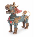 AN ORIENTAL GILT BRASS BUDHISTIC DRAGON LION with jewelled coral coloured and turquoise decoration