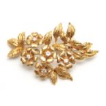 AN 18CT YELLOW GOLD FLOWERHEAD AND LEAF SPRAY BROOCH set with five diamonds