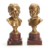 A PAIR OF LATE 19TH CENTURY GILT BRONZE BUSTS OF GIRL AND BOY mounted on veined red marble socles