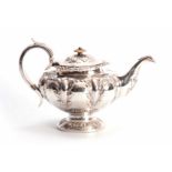 A VICTORIAN SILVER TEAPOT OF LARGE SIZE of circular footed form with hinged lid and leaf capped