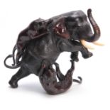 A JAPANESE MEIJI PERIOD PATINATED BRONZE SCULPTURE modelled as an elephant being attacked by two