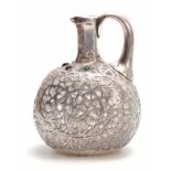 A 19TH CENTURY JEWELLED AND BRIGHT CUT SILVER FILIGREE OVERLAID GLASS CLARET JUG of flattened