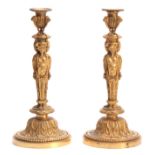 A PAIR OF 19TH CENTURY FRENCH ROCOCO BRONZE AND ORMOLU FIGURAL CANDLESTICKS with lions head urn-